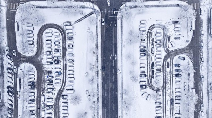 An aerial view of traffic and parked cars during heavy snowfall in Alipasino Polje neighborhood of Sarajevo, Bosnia, Monday, Dec. 23, 2024. (AP Photo/Armin Durgut)