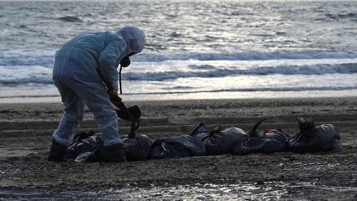 Volunteers work to clear spilled oil on the coastline following an incident involving two tankers damaged in a storm in the Kerch Strait, in the settlement of Blagoveshchenskaya near the Black Sea resort of Anapa in the Krasnodar region, Russia December 21, 2024. REUTERS/Sergey Pivovarov TPX IMAGES OF THE DAY