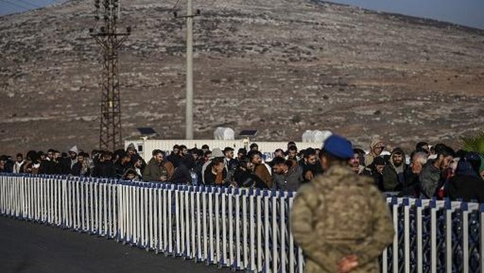 (FILES) Syrians who live in Turkey wait in a queue at Cilvegozu crossborder gate before entering in Syria at Reyhanli district in Hatay, on December 9, 2024. More than 25,000 Syrians have returned home from Turkey since Bashar al-Assad was overthrown by Islamist-led HTS rebels, Turkeys interior minister said December 24, 2024. (Photo by Ozan KOSE / AFP)