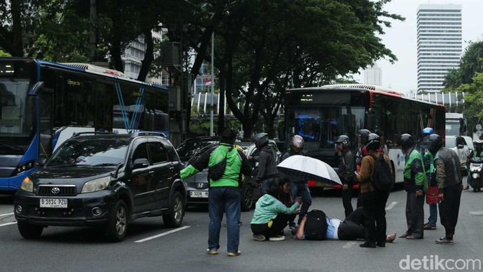 Momen Kompak Polisi-Warga Tolong Korban Lakalantas Polisi dan warga sedang menolong korban kecelakaan lalu lintas di Jalan Jenderal Sudirman, Jakarta, Selasa (24/12/2024).