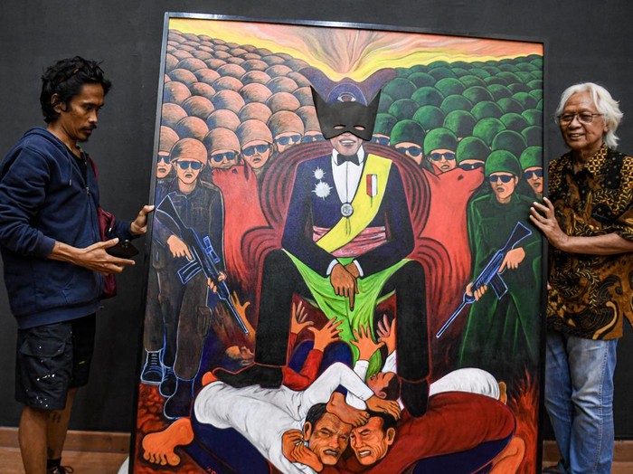 Momen Yos Suprapto Turunkan Lukisan Kontroversialnya dari Galeri Nasional Perupa senior Yos Suprapto (kanan) bersama petugas menurukan salah satu karya lukisannya yang bertajuk βKebangkitan: Tanah Untuk Kedaulatan Panganβ yang sebelumnya akan dipamerakan di Galeri Nasional, Jakarta, Senin (23/12/2024). Penurunan karya lukisan tersebut dilakukan sebagai bentuk kekecewaan Yos terhadap Galeri Nasional Indonesia sebagai pemilik tempat yang meminta lima dari 30 lukisannya diturunkan. ANTARA FOTO/Muhammad Adimaja/wpa.