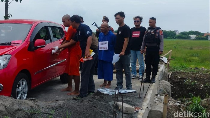 Dua pelaku pembunuhan wanita yang mayatnya ditemukan di bawah jembatan Losari, Brebes, saat menjalani reka ulang, Selasa (24/12/2024).