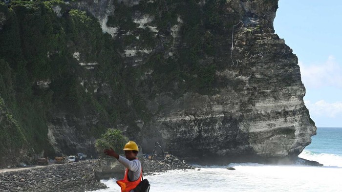 Pekerja melakukan proses pengerjaan penanganan tebing retak di Pura Uluwatu, Badung, Bali, Selasa (24/12/2024). Proyek penanganan tebing retak di objek wisata Pura Uluwatu dengan sejumlah pengerjaan seperti perlindungan dan perbaikan tebing serta pembangunan pengaman pantai (revetment) tersebut saat ini telah mencapai progres sekitar 70 persen dan diperkirakan selesai pada pertengahan Januari 2025. ANTARA FOTO/Fikri Yusuf/nym.