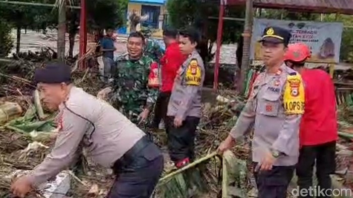 Tim SAR Polres Maros, membantu warga memberishkan sampah sisa banjir bandang di Kecamatan Camba dan Cenrana.