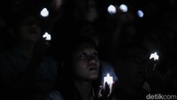 Cahaya lilin yang dinyalakan jemaat menerangi Indonesia Arena saat Misa Malam Natal.  