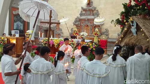 Prosesi Perarakan Misa Natal bersama pastor dan beberapa putra altar di Gereja Paroki Roh Kudus Babakan, Canggu, Badung, Bali, Selasa (24/12/2024). (Foto: Aryo Mahendro/detikBali)