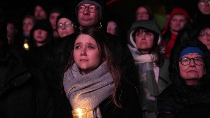 People lay flowers and candles in front of the Johannis church close to the Christmas market where a car drove into a crowd on Friday evening, in Magdeburg, Germany, Monday, Dec. 23, 2024. (AP Photo/Ebrahim Noroozi)