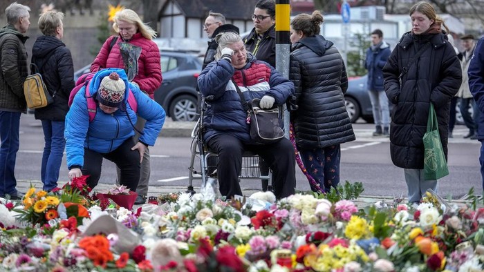 People lay flowers and candles in front of the Johannis church close to the Christmas market where a car drove into a crowd on Friday evening, in Magdeburg, Germany, Monday, Dec. 23, 2024. (AP Photo/Ebrahim Noroozi)