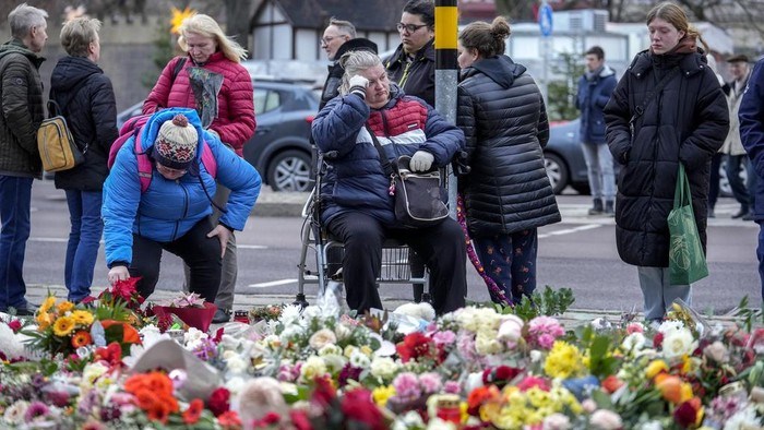 Suasana Duka Selimuti Jerman Usai Serangan Mematikan di Pasar Natal People lay flowers and candles in front of the Johannis church close to the Christmas market where a car drove into a crowd on Friday evening, in Magdeburg, Germany, Monday, Dec. 23, 2024. (AP Photo/Ebrahim Noroozi)
