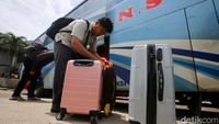 Pemudik memasukan tas ke bagasi bus.