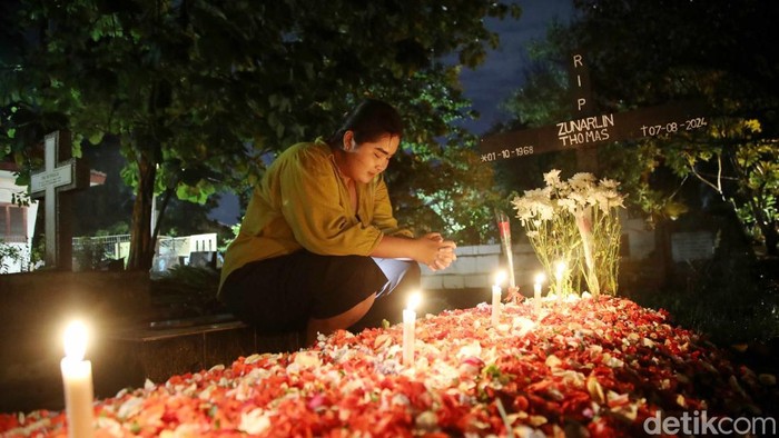 Tradisi Ziarah Kubur Warga Keturunan Portugis Warga keturunan Portugis berdoa saat melakukan ziarah di makam keluarganya pada malam Natal di kawasanΒ Gererja Protestan Indonesia Barat Tugu, Semper Barat, Jakarta Utara, Selasa (24/12/2024).