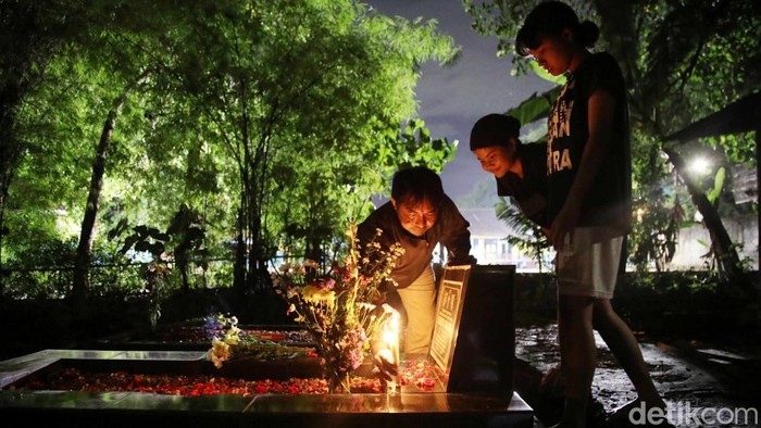 Tradisi Ziarah Kubur Warga Keturunan Portugis Warga keturunan Portugis berdoa saat melakukan ziarah di makam keluarganya pada malam Natal di kawasanΒ Gererja Protestan Indonesia Barat Tugu, Semper Barat, Jakarta Utara, Selasa (24/12/2024).