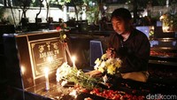 Suasana malam di pemakaman gereja Tugu Jakarta pun tampak lain. Cahaya lilin berkelip di hampir beberapa area pemakaman.