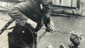 Tentara Jerman Timur Membantu Seorang Anak Kecil Menyelinap Melintasi Tembok Berlin, 13 Agustus 1961 Foto: Boredpanda