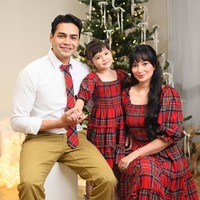 Keluarga Asmirandah dan Jonas Rivanno menampilkan semangat Natal dengan busana motif tartan warnah merah-hitam. Tampak pohon Natal dengan desain simple berhias pita dan lampu sebagai dekorasi yang mempercantik rumah. Foto: Dok. Instagram