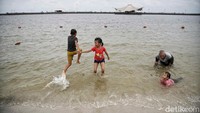 Tampak anak-anak riang gembira bermain di pantai.
