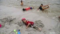 Selain bermain air, anak-anak juga bermain pasir.