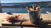 Selain tiram, tersedia juga menu seafood segar lainnya seperti udang hingga kepiting. Yang semuanya disajikan di atas meja kayu, yang setengahnya terendam air laut. Foto: Site/Pool