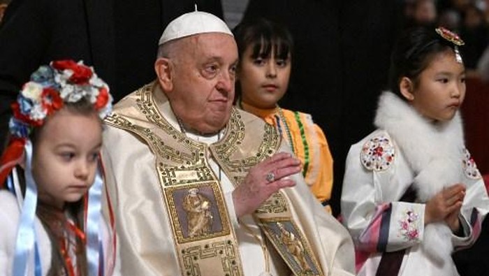 Pope Francis is surrounded by children at the end of the Christmas Eve mass at The St Peters Basilica in the Vatican on December 24, 2024. Pope Francis marks Christmas Eve with a special ceremony launching Jubilee 2025, a year of Catholic celebrations set to draw more than 30 million pilgrims to Rome. Over the next 12 months, pilgrims will pass through the large and imposing bronze door, which is normally closed, by tradition benefiting from a 