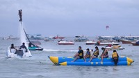 Wisatawan bermain wahana banana boat di Pantai Tanjung Benoa, Kuta Selatan, Badung, Bali, Rabu (25/12/2024).