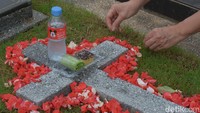 Warga menabur bunga di makam keluarganya. 