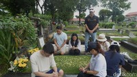 Warga berdoa, merenung dan menabur bunga saat mengunjungi makam keluarga di Hari Natal. 