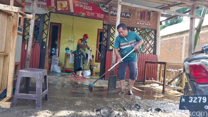 Warga Kelurahan Lesanpuro bersih-bersih usai banjir.