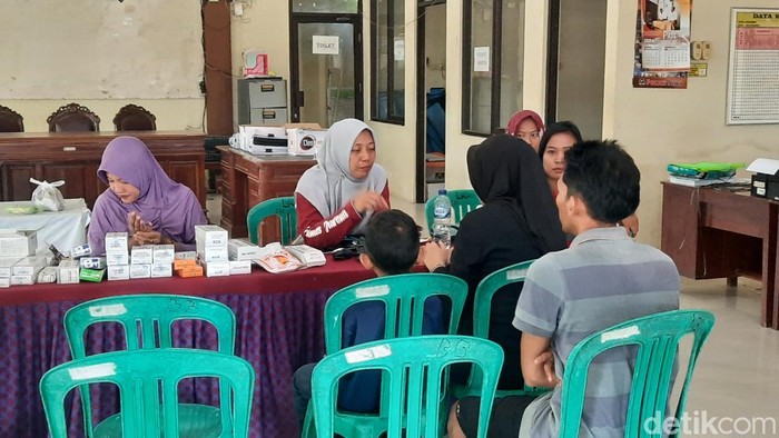 Warga mengalami keluagan muntah dan demam saat mendatangi posko Kesehatan di Balai Desa Tluwah Kecamatan Juwana, Kabupaten Pati, Rabu (25/12/2024).