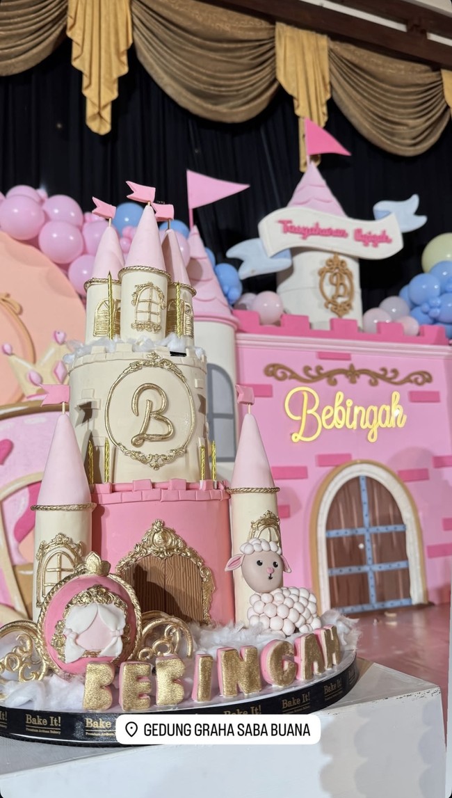 Digelar meriah, dekorasi di acara akikah Bebingah juga terlihat mewah dengan dominasi warna merah muda. Berbentuk seperti layaknya kastil, pada bagian tengahnya terdapat inisial dan nama Bebingah. Kue akikahnya juga dibuat berbentuk mirip dengan dekorasi di acara tersebut. Foto: Instagram