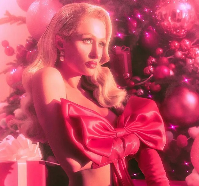 Penampilan berbeda ditunjukkan Paris Hilton. Dia mengunggah foto berlatar pohon Natal dengan gaya nyaris tanpa busana. Paris hanya menutupi tubuhnya dengan pita raksasa. Foto: Dok. Instagram