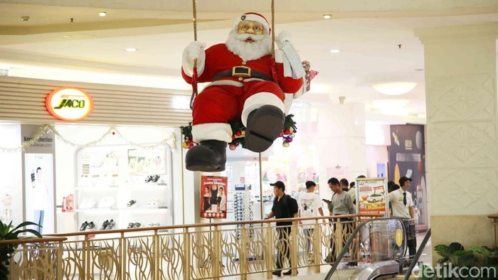 Sejumlah pengunjung melintasi pernak pernik dekorasi Natal di  Mal Artha Gading, Jakarta Utara, Kamis (26/12/2024).