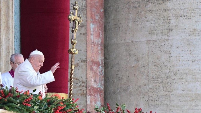 Pope Francis greets the crowd from the main balcony of St. Peters basilica after the Urbi et Orbi message and blessing to the city and the world as part of Christmas celebrations, at St Peters square in the Vatican on December 25, 2024. (Photo by Tiziana FABI / AFP)