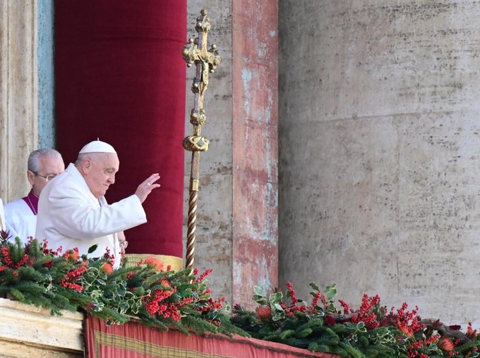 Pope Francis greets the crowd from the main balcony of St. Peters basilica after the Urbi et Orbi message and blessing to the city and the world as part of Christmas celebrations, at St Peters square in the Vatican on December 25, 2024. (Photo by Tiziana FABI / AFP)