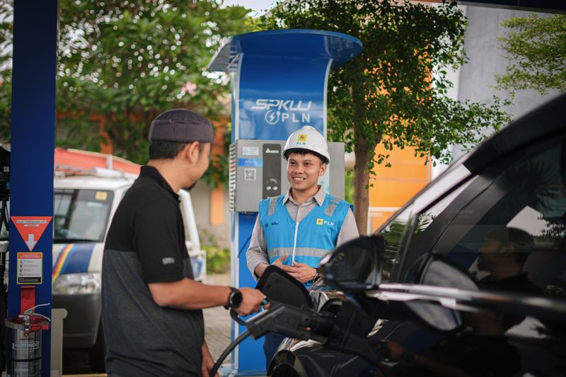 Pemilik mobil mengisi daya di SPKLU.