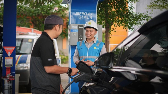 Pemilik mobil mengisi daya di SPKLU.