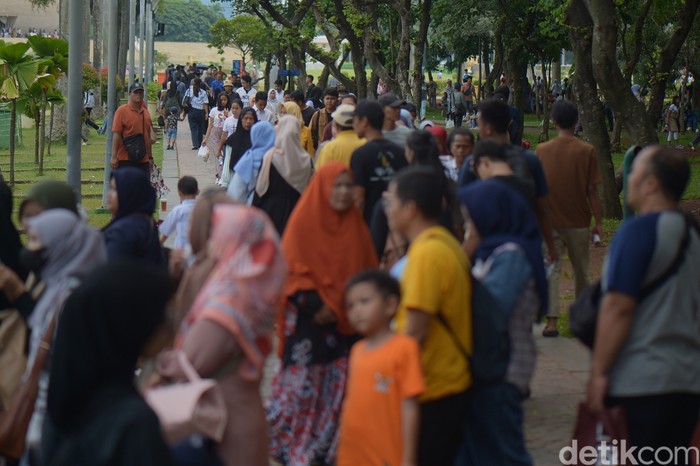 Masyarakat antre untuk naik mobil shuttle di Monas, Jakarta, Kamis (26/12/2024).