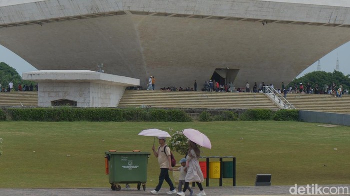 Masyarakat antre untuk naik mobil shuttle di Monas, Jakarta, Kamis (26/12/2024).