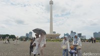 Beberapa di antara mereka tampak mengambil gambar atau berpose di depan Monas. Ada pula pengunjung yang sedang berolahraga.