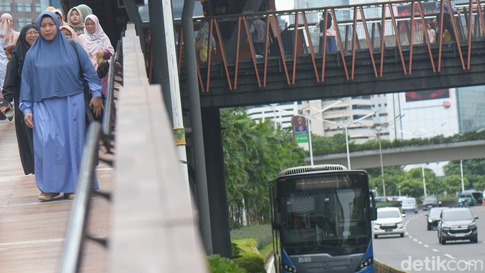 Calon penumpang menunggu kedatangan aramda bus TransJakarta koridor I (Blok M-Kota Tua), di Jl Sudirman, Jakarta, Kamis (26/12/2024).