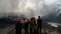 Petugas berusaha memadamkan api saat kebakaran kapal nelayan di Pelabuhan Tegal, Jawa Tengah, Jumat (27/12/2024). (ANTARA FOTO/Oky Lukmansyah)