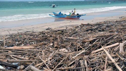 Nelayan memindahkan sampah kayu yang berserakan di kawasan Pantai Kedonganan, Badung, Bali, Jumat (27/12/2024). Sampah kiriman berupa kayu, bambu, dan plastik yang berserakan di pesisir pantai sejak awal Desember 2024 itu dikeluhkan nelayan karena menyebabkan perahu rusak dan kesulitan saat memarkir perahu usai melaut. ANTARA FOTO/Nyoman Hendra Wibowo/rwa.