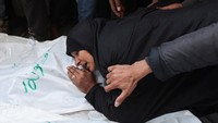 Seorang wanita menangisi jenazah korban. 
