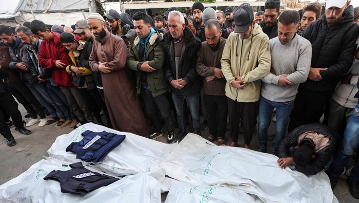 Jurnalis Palestina Tewas Dibom Israel Palestinians stand near the remains of a broadcasting vehicle following an Israeli airstrike that killed five journalists from Al-Quds Al-Youm television channel near Al-Awda Hospital, according to medics with the Gaza health authorities, amid the ongoing conflict between Israel and Hamas in Nuseirat, central Gaza Strip, December 26, 2024. REUTERS/Ramadan Abed TPX IMAGES OF THE DAY