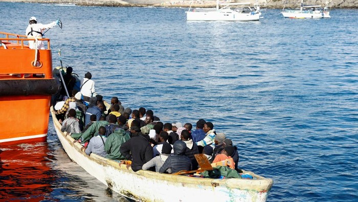A Spanish Coast Guard vessel tows a fibreglass boat with migrants onboard to the port of Arguineguin, on the island of Gran Canaria, Spain, December 25, 2024. REUTERS/Borja Suarez