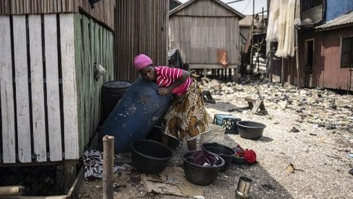 A woman does her laundry in the Ago Egun community slum in Bariga neighbourhood in Lagos, on November 30, 2024. (Photo by OLYMPIA DE MAISMONT / AFP)