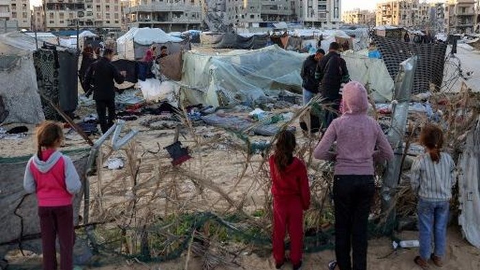 People inspect the site of reported Israeli bombardment on tents sheltering Palestinians displaced from Beit Lahia at a camp in Khan Yunis in the southern Gaza Strip on December 25, 2024 amid the ongoing war in the Palestinian territory between Israel and Hamas. (Photo by BASHAR TALEB / AFP)