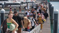 Wisatawan antre menaiki kapal cepat di Pelabuhan Sanur, Denpasar, Bali, Jumat (27/12/2024).