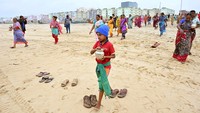 Penduduk di Chennai, India, membawa botol susu untuk dituangkan ke Teluk Benggala dalam rangka mengenang korban tsunami Samudra Hindia 2004 pada peringatan 20 tahun tragedi tersebut. (REUTERS/Riya Mariyam R)