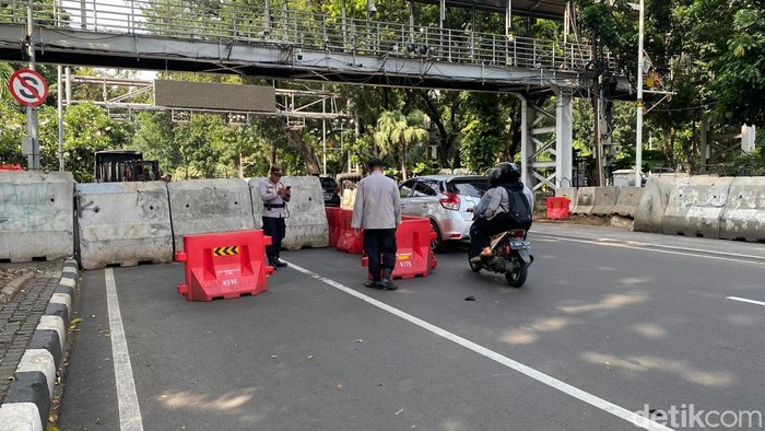 Polisi mulai menutup arus lalin Jalan Medan Merdeka Barat arah Istana menjelang demo tolak PPN 12% di Patung Kuda.