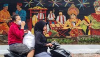 Warga melintas di dekat mural kebudayaan dan mural para Gubernur DKI Jakarta di Jalan Bukit Duri Utara, Jakarta, Jumat (27/12/2024).  